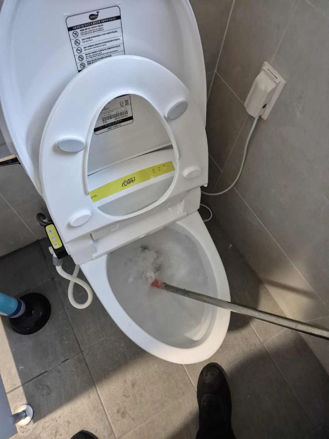 변기에 관통 도구를 넣어 작업하는 장면