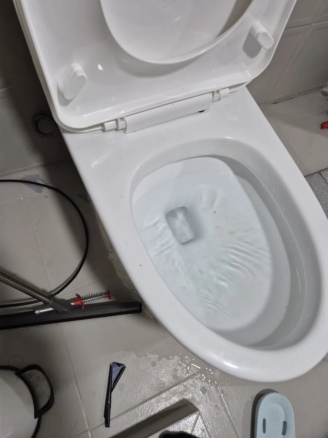 물이 찬 변기에 스프링 관통기를 넣어 작업하는 장면