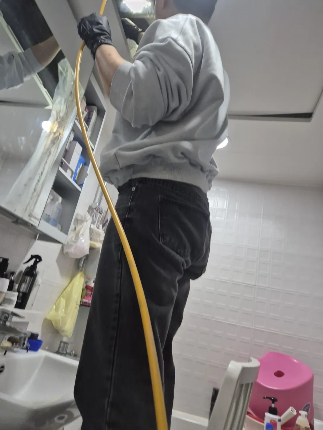 천장 개구부 배관에 스프링을 투입하는 작업자