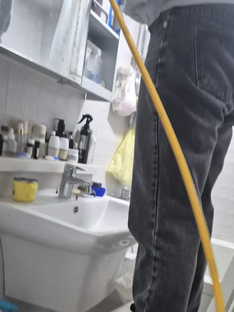 호매실동 하수구 작업으로 욕실 안에 스프링 장비의 노란 케이블을 끌어온 모습